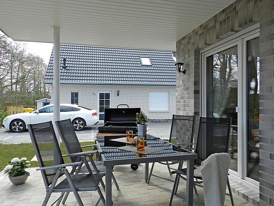 Die Terrasse mit Gartenmöbeln und Grill